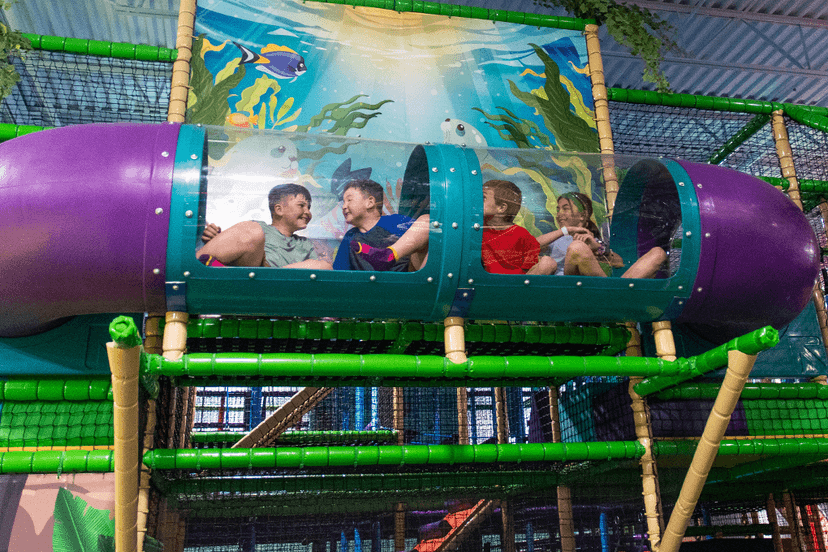 Children playing inside a colorful indoor playground tunnel