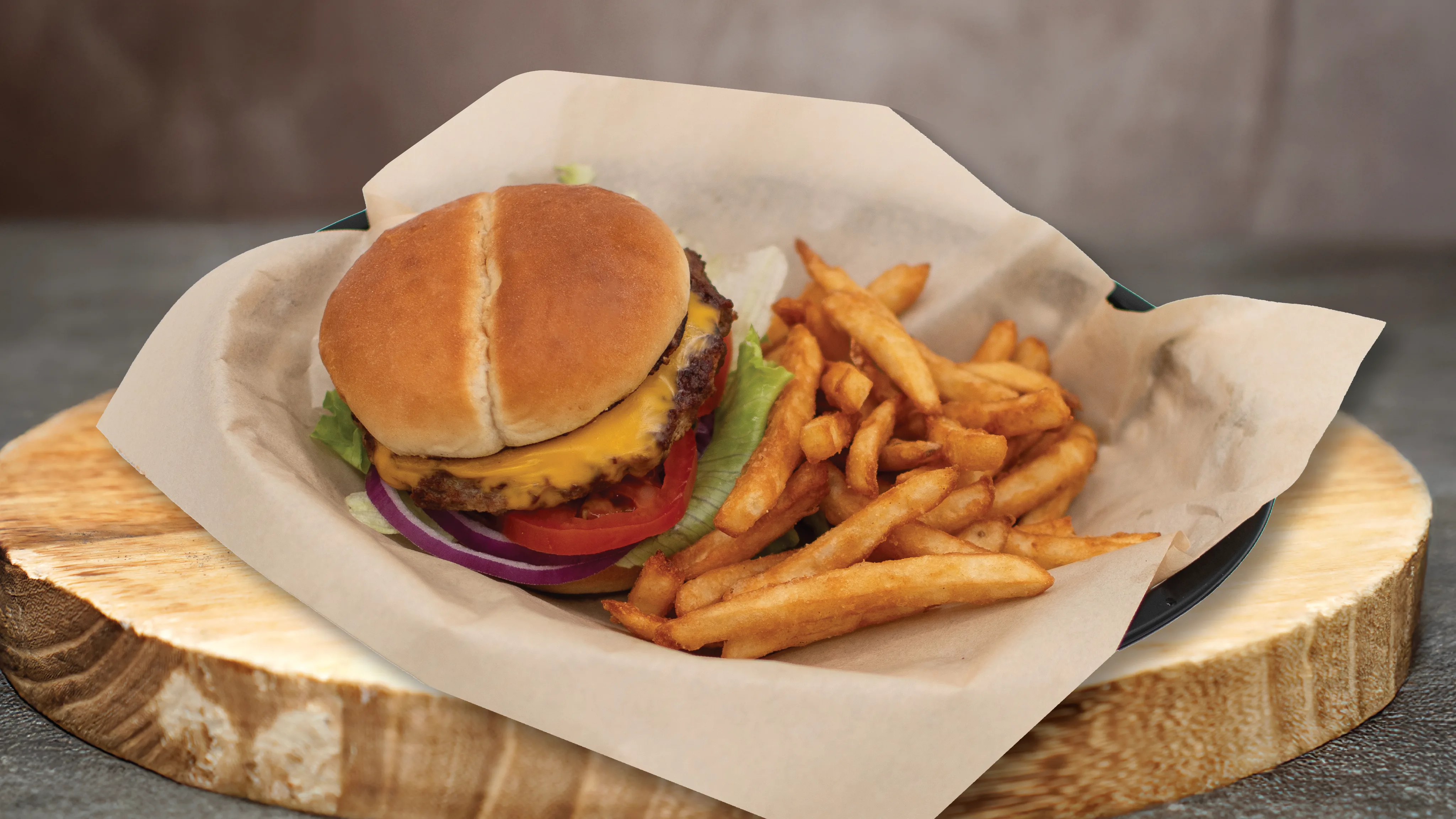 A cheeseburger and fries served in a basket
